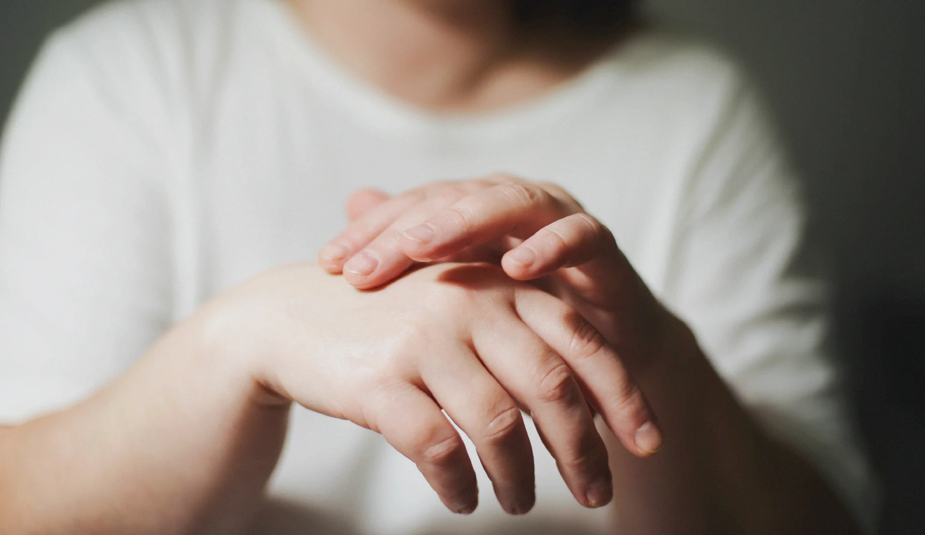 Une personne serrant sa main droite enflée