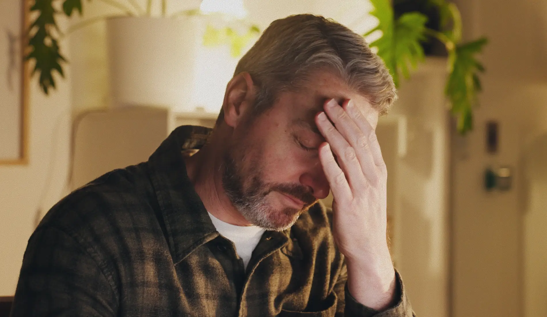 Une personne, dont les résultats d'analyse démontrent une hémochromotose, se tient le front.