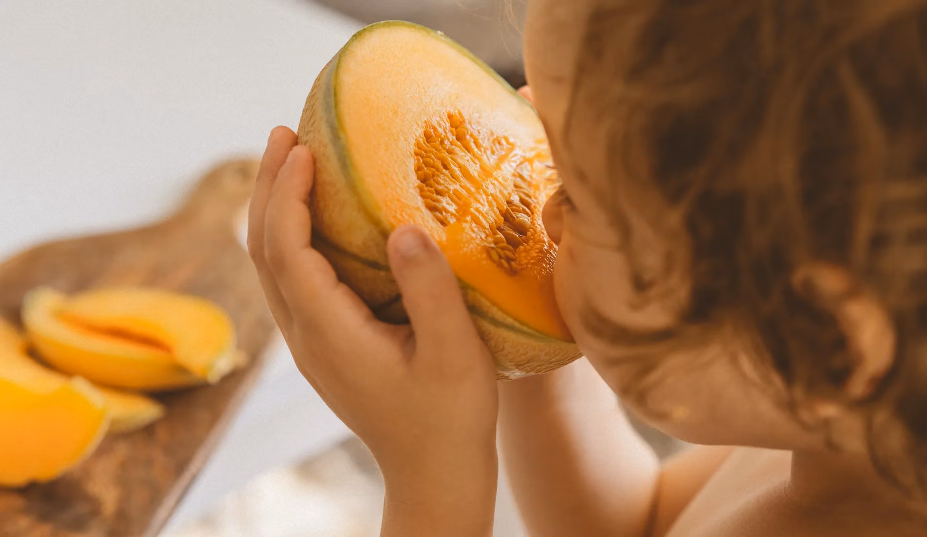 Un enfant souffrant d'allergies croisées, en train de manger une papaye.