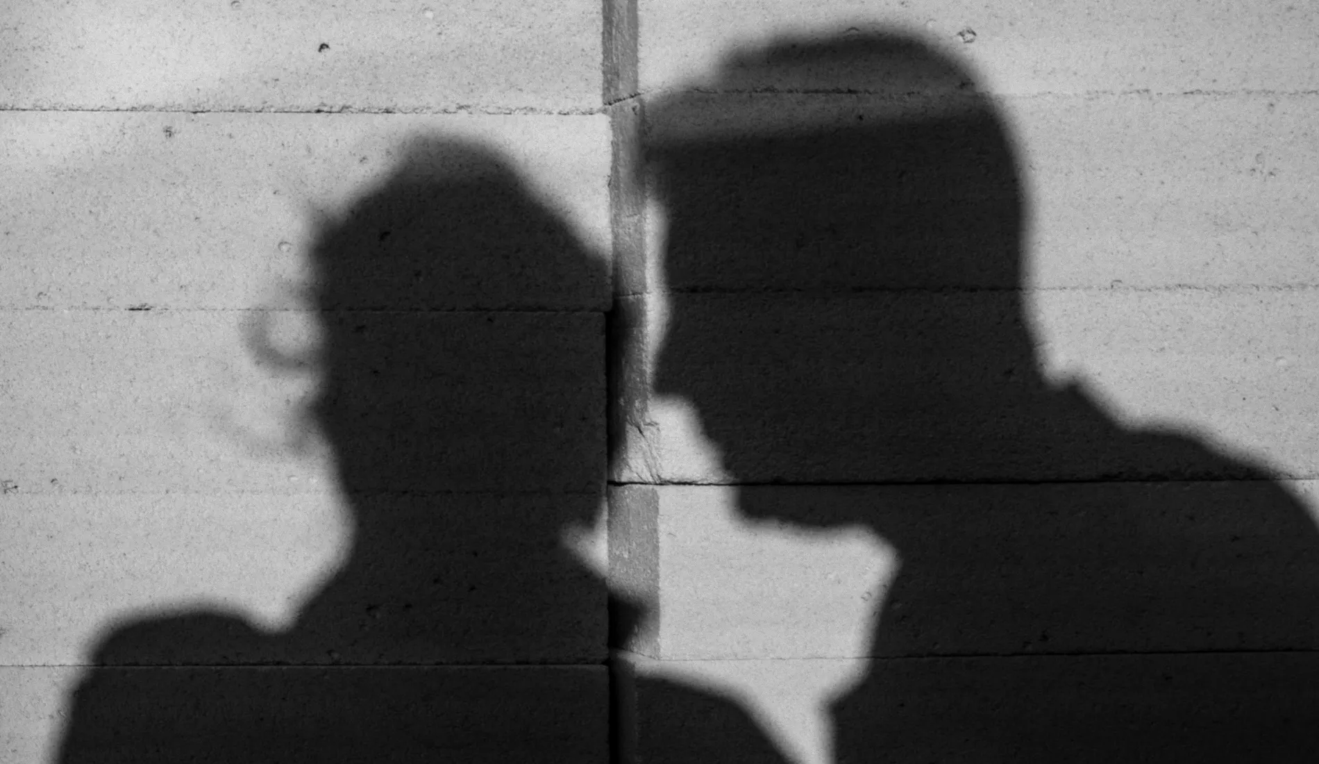Deux personnes dans l'ombre : une victime et un pervers narcissique.