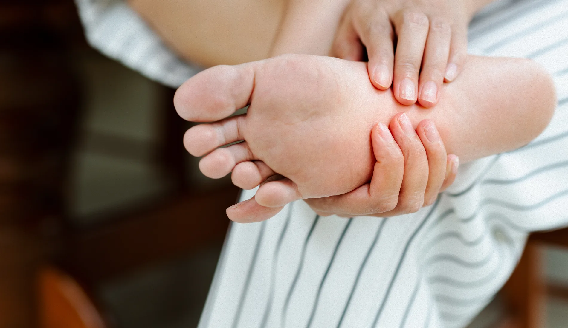 Une personne souffrant de tatalgie, qui se masse le pied.