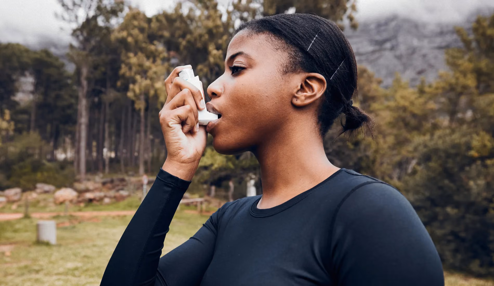 Une jeune dame en train d'inhaler un produit car elle souffre d'asthme