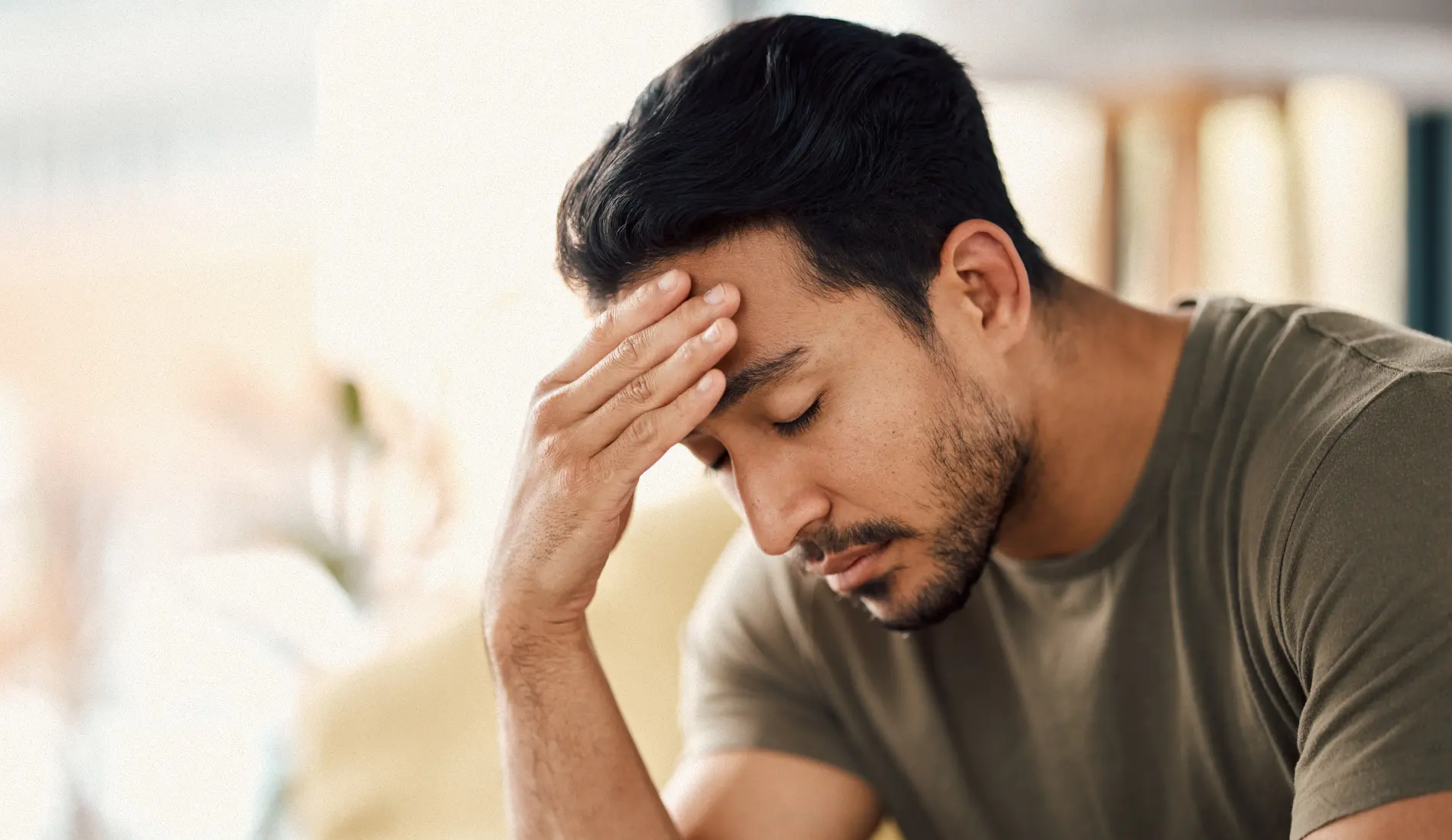 Personne au teint pâle, à l'air épuisé, et se tenant la tête, symptômes caractéristiques d'une hypotension artérielle associée à une tension insuffisante