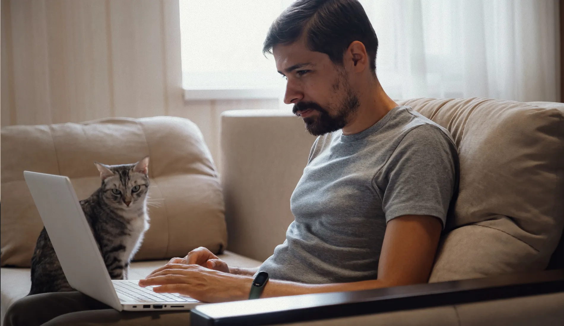Personne assise sur son canapé, ordinateur sur les genoux, illustrant la téléconsultation à domicile et la question de la protection des données médicales partagées en ligne.