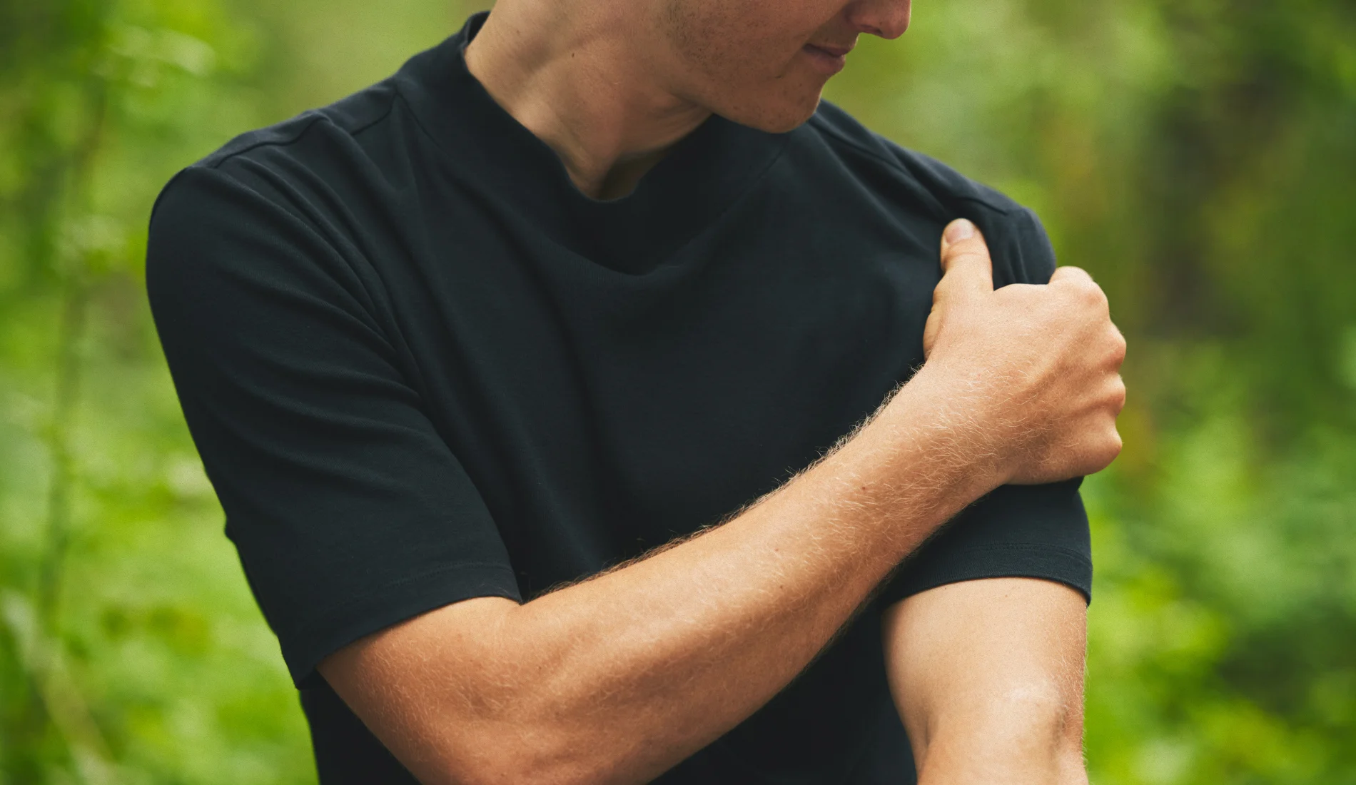 Un jeune homme qui se touche le bras gauche, signe d'une douleur ressentie.
