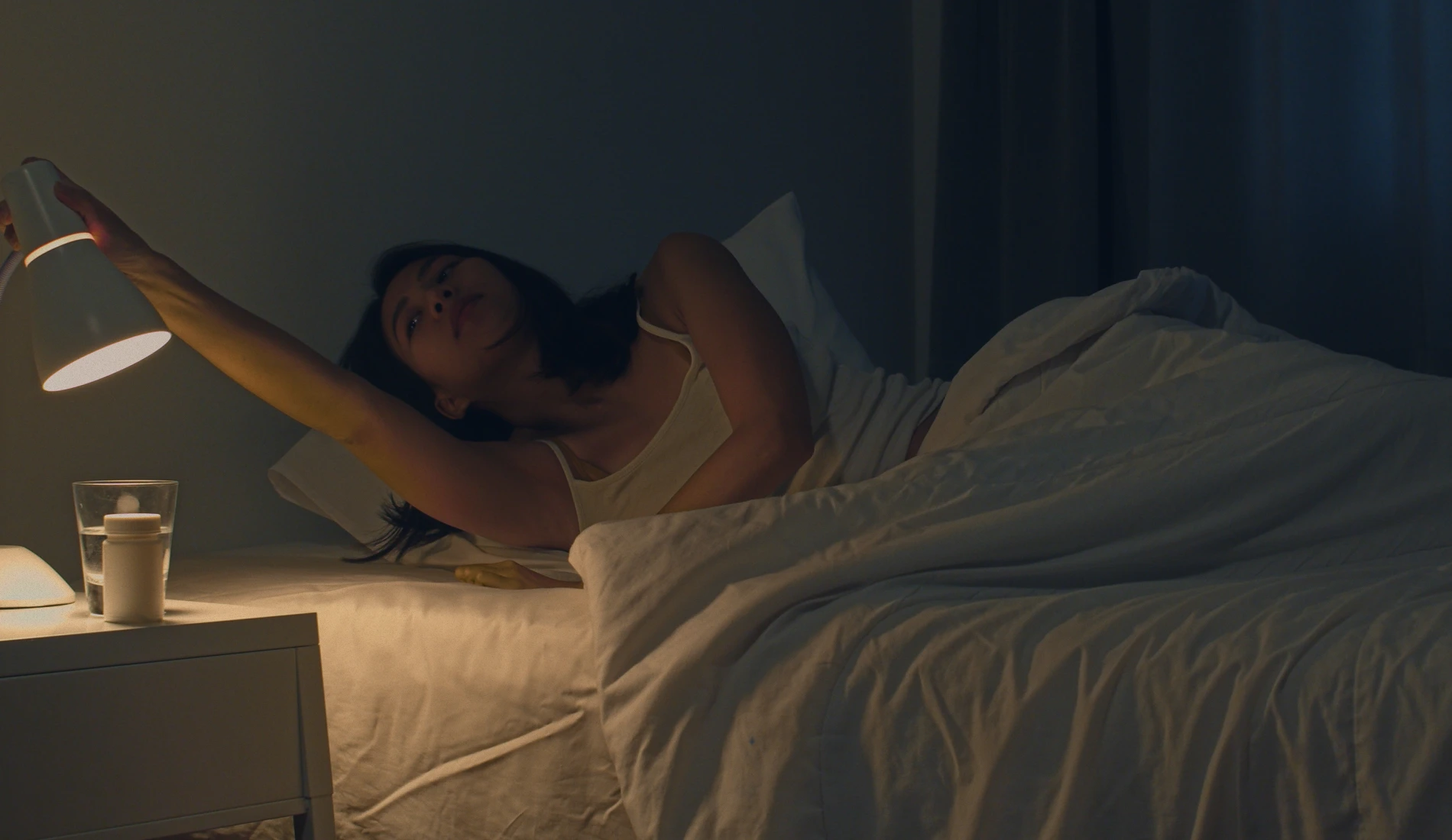 Une adulte en train de se lever de son lit, car elle vient de faire pipi au lit, signe d'énurésie.