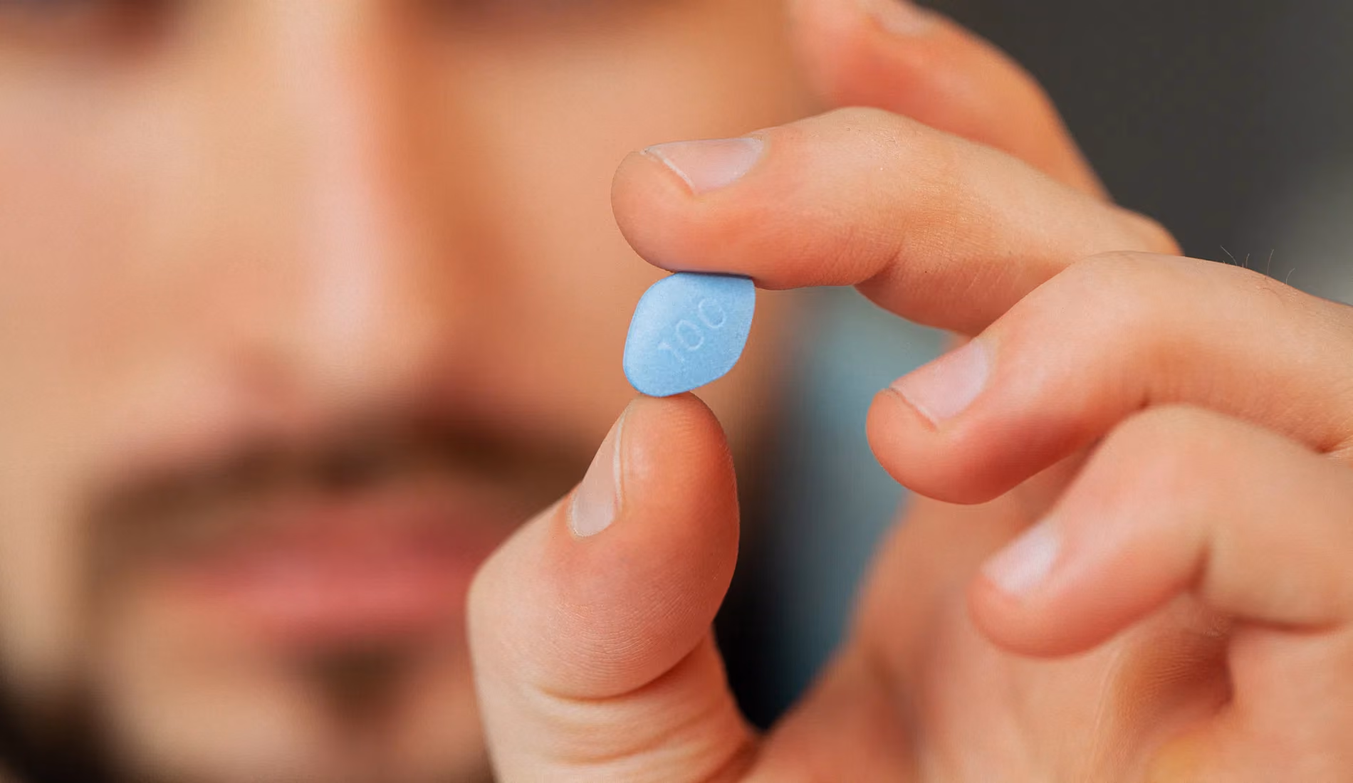 Homme tenant un comprimé de Viagra (sildénafil), un médicament à obtenir légalement sur ordonnance en France