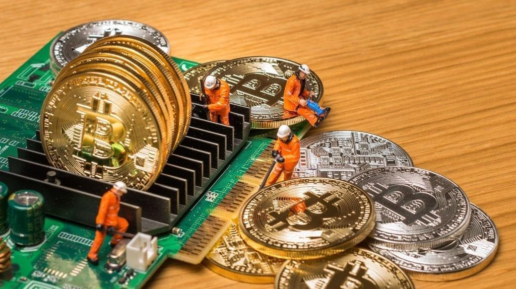Uma placa de computador para mineração rodeada de moedas