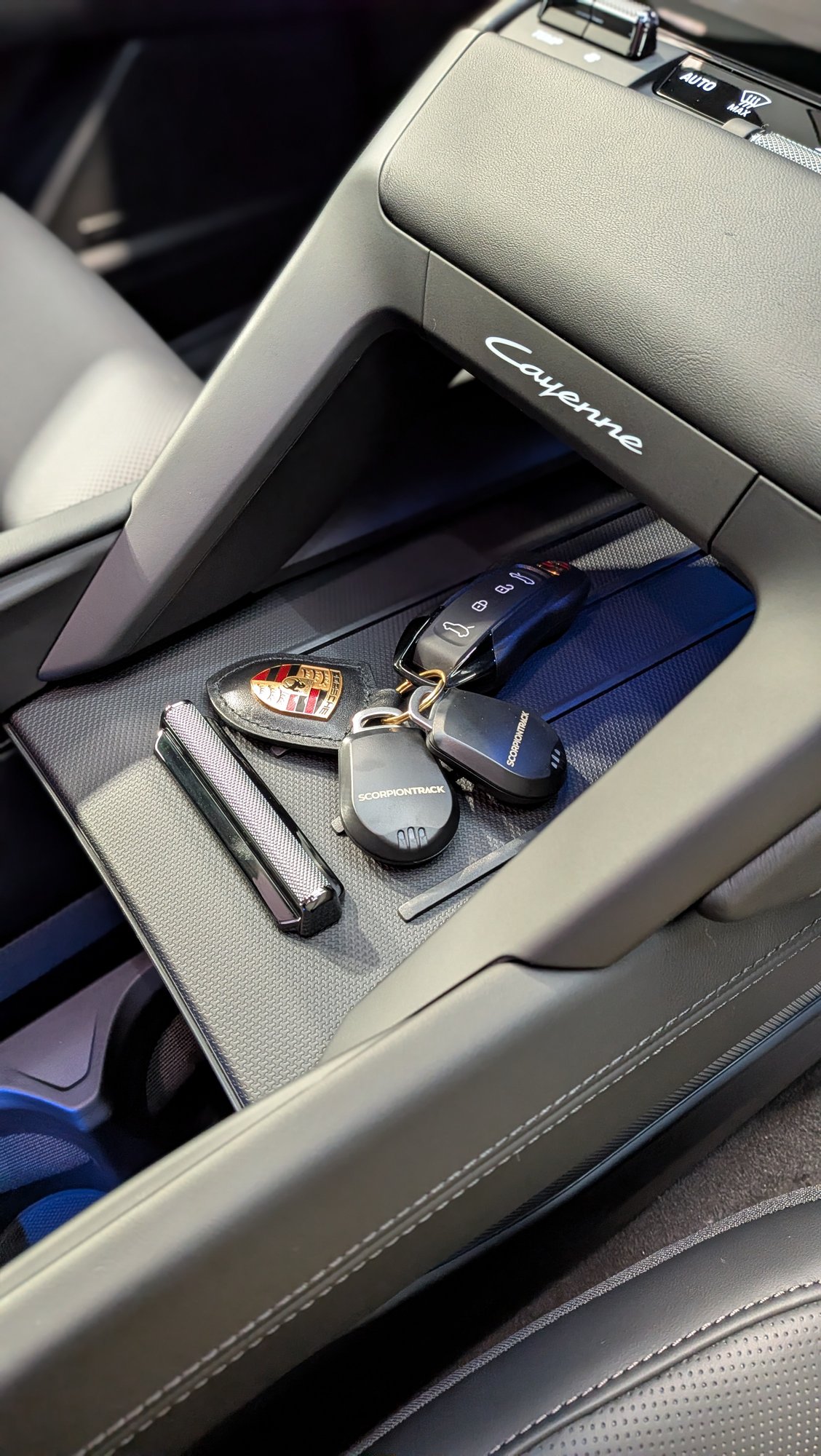 Porsche key with ScorpionTrack tracker tags on a Cayenne centre console