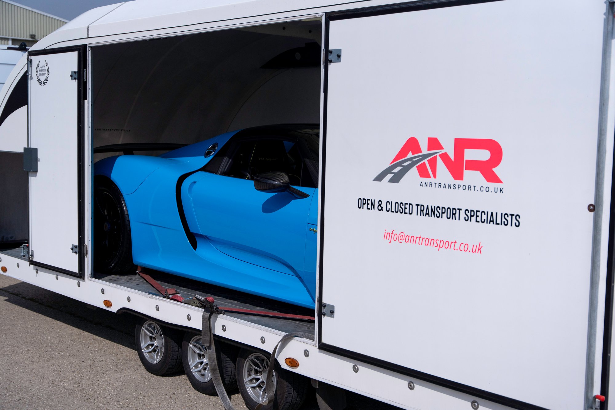 Porsche 918 Spyder strapped down inside an enclosed trailer