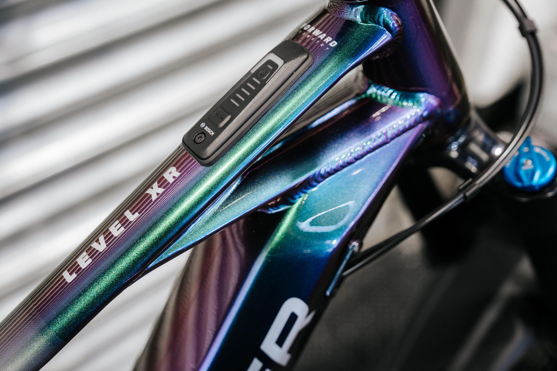 Close-up of an iridescent e-bike top tube with a Bosch display