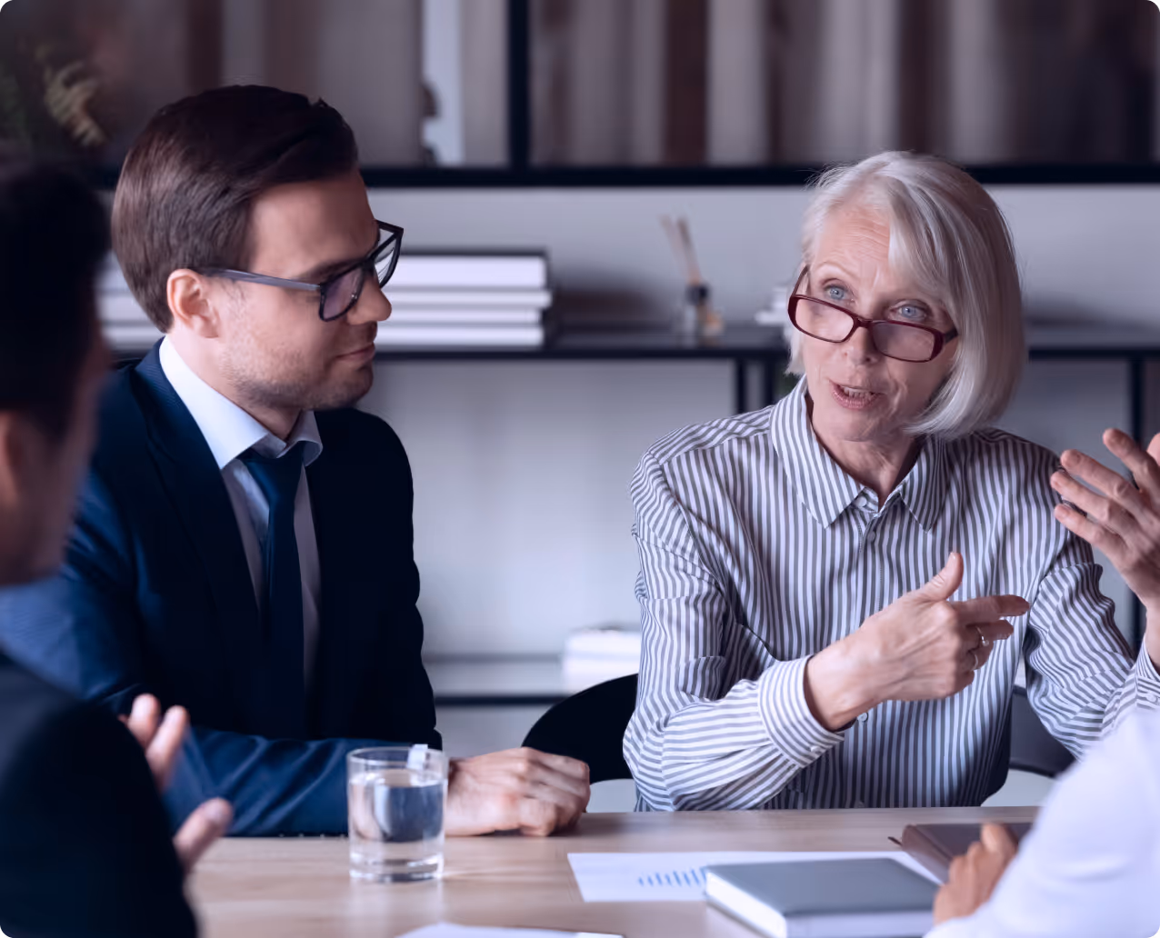 A person talking to a group of people in a business meeting