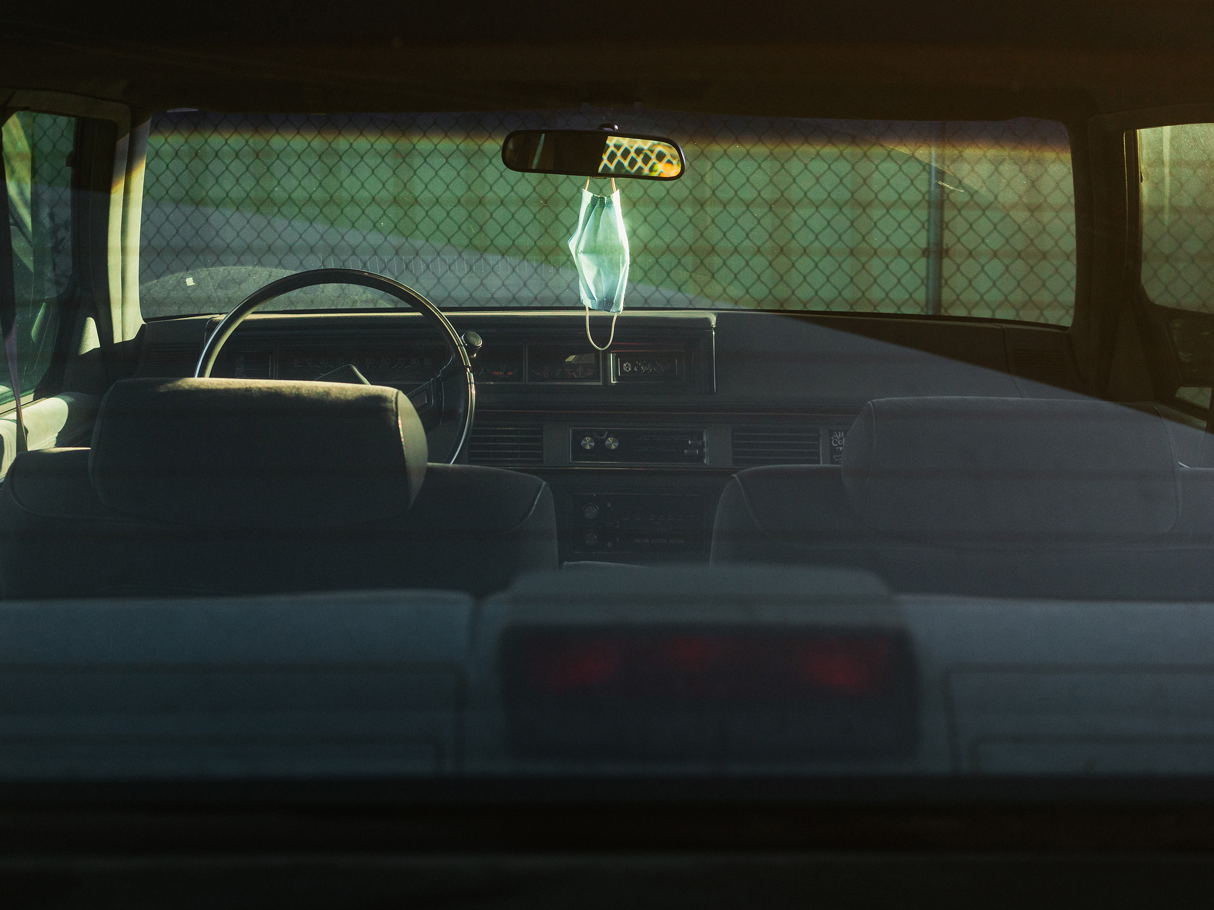 A mask hangs over a car console.