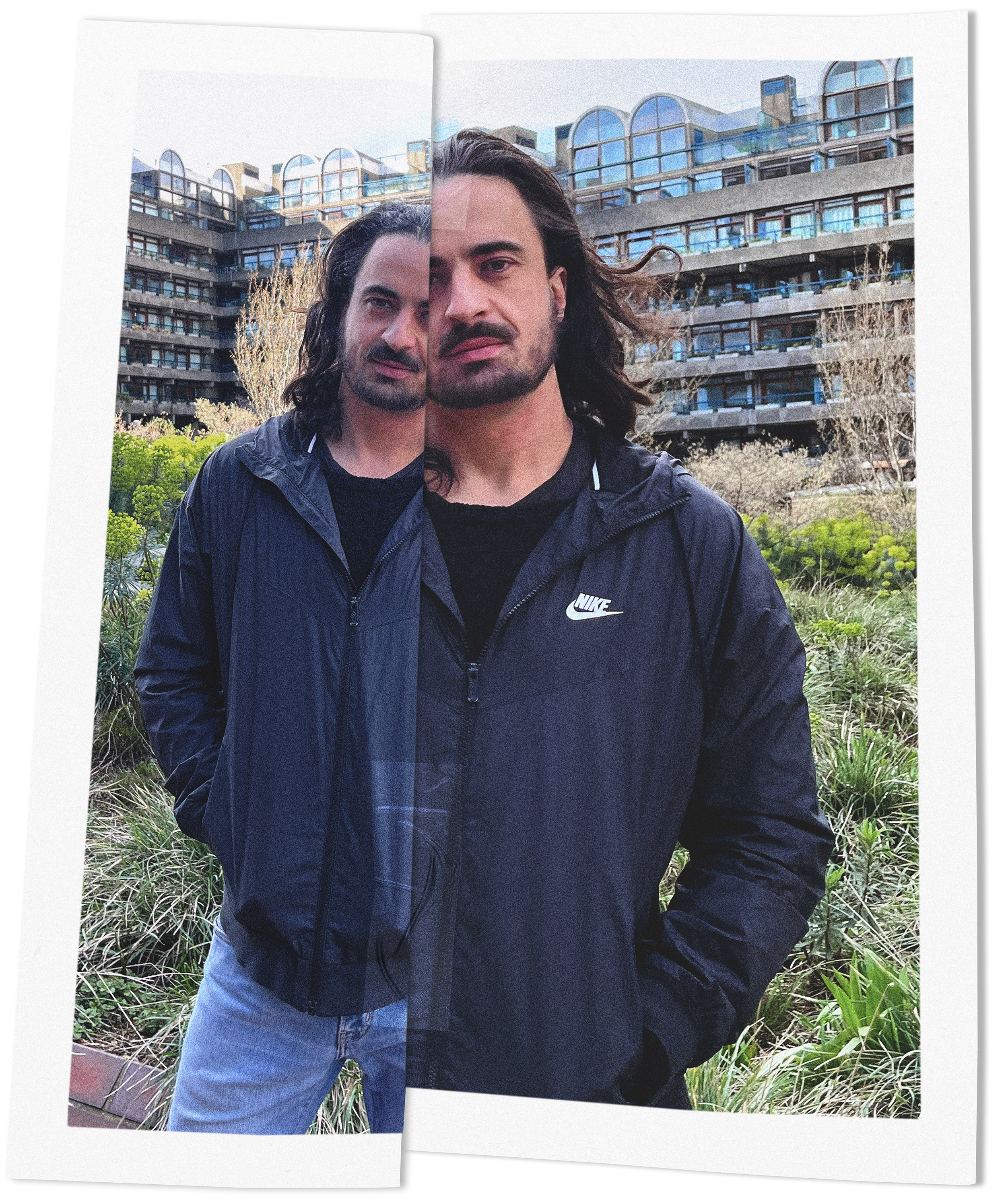 Photo of Gregor Vogel in front of a white background, wearing a black T-shirt and holding colourful flowers. The picture was taken by Yarin Shmerling.