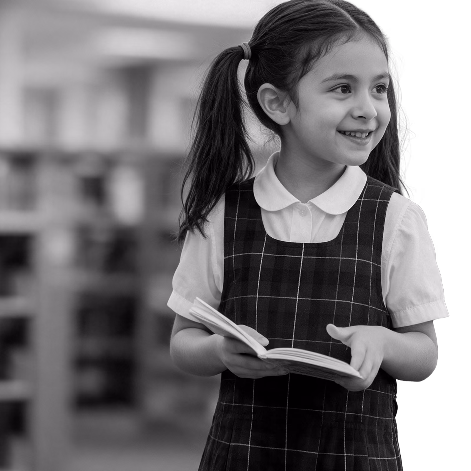 lower school girl in uniform holding a book in the library