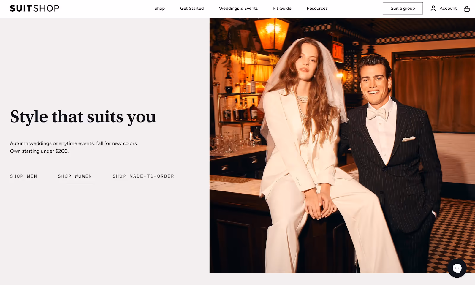 SuitShop homepage featuring a woman in a white suit with a veil and a man in a black pinstripe tuxedo, promoting wedding fashion.
