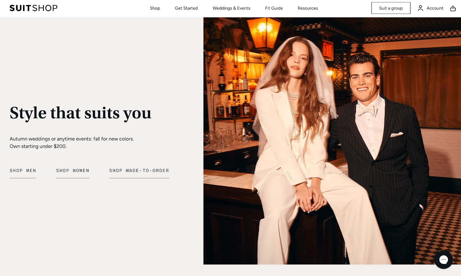 SuitShop homepage featuring a woman in a white suit with a veil and a man in a black pinstripe tuxedo, promoting wedding fashion.