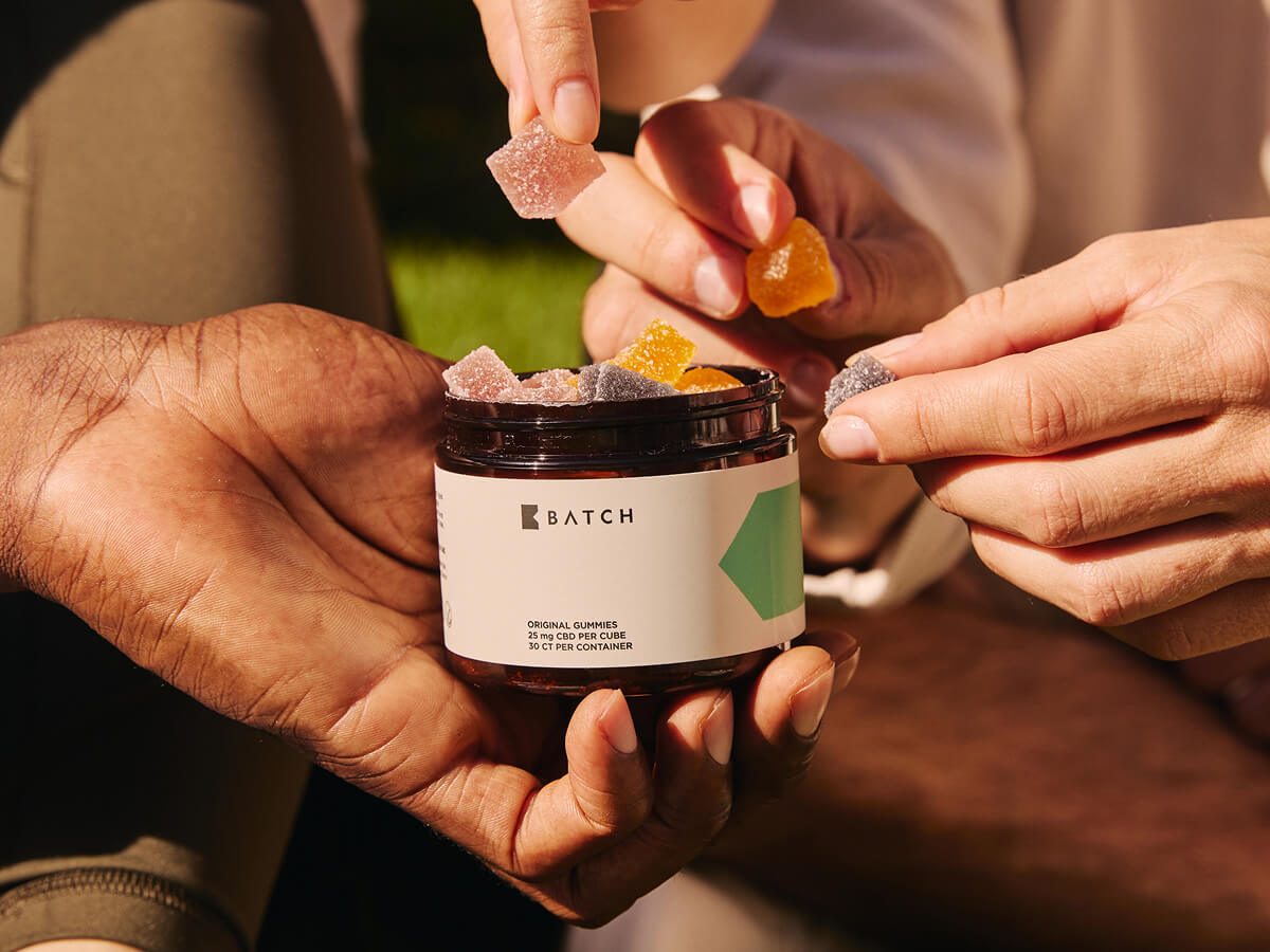 A close up on a container of gummies, being held by a pair of hands.