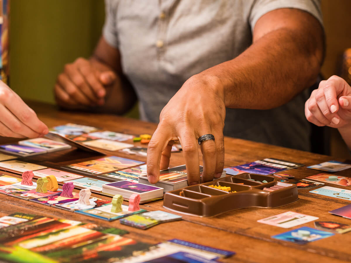 A man grabbing a card for a tabletop game.
