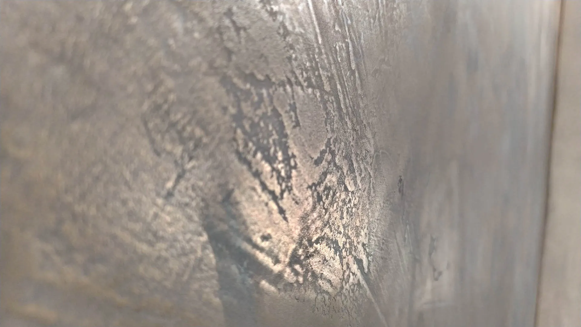 Close-up of silver metallic microcement wall finish