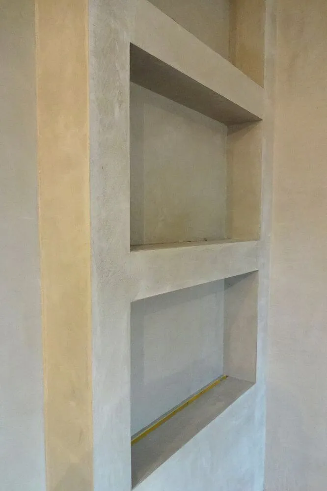 Recessed shelving niches finished in light grey microcement