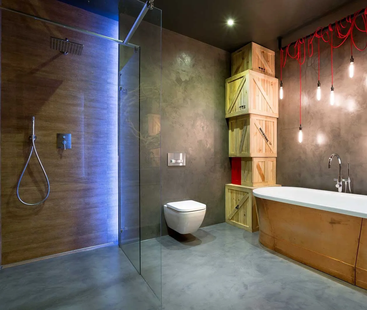 Bathroom with grey microcement walls and floor, walk-in shower, wall-hung WC and freestanding bath