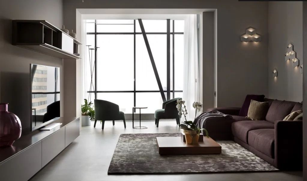 Living room with seamless light grey microcement floor and floor-to-ceiling windows