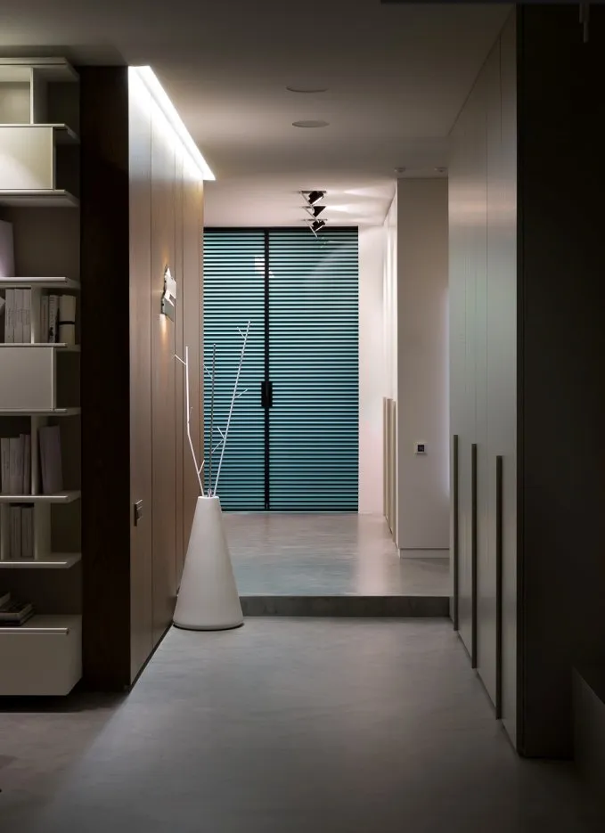 Hallway with grey microcement floor, fitted wardrobes and shelving