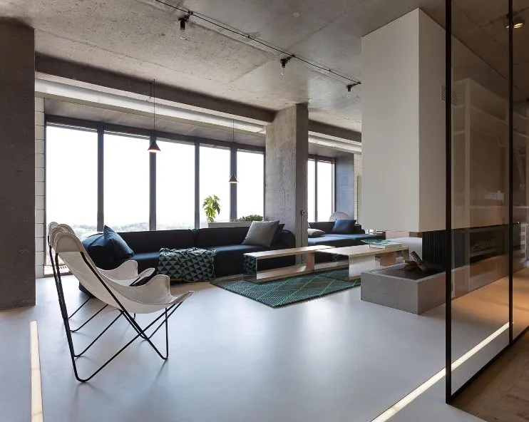 Open-plan living area with seamless light grey microcement floor and full-height windows