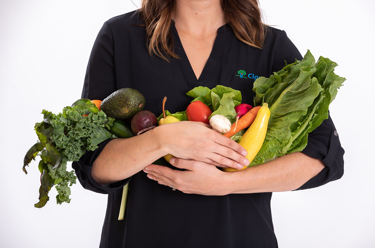 woman holding fruits and vegetables