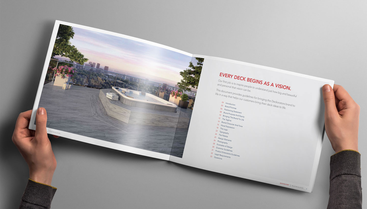 Two hands holding the brand identity guide, opened up to an inside page.