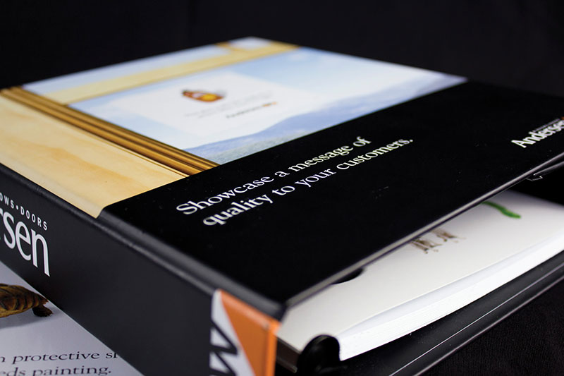 Close-up of black Andersen Windows binder with papers inside.