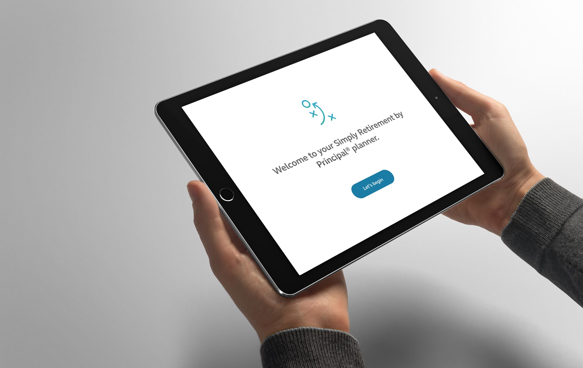 Two hands holding a tablet with the Simply Retirement by Principal planner pulled up on the screen.