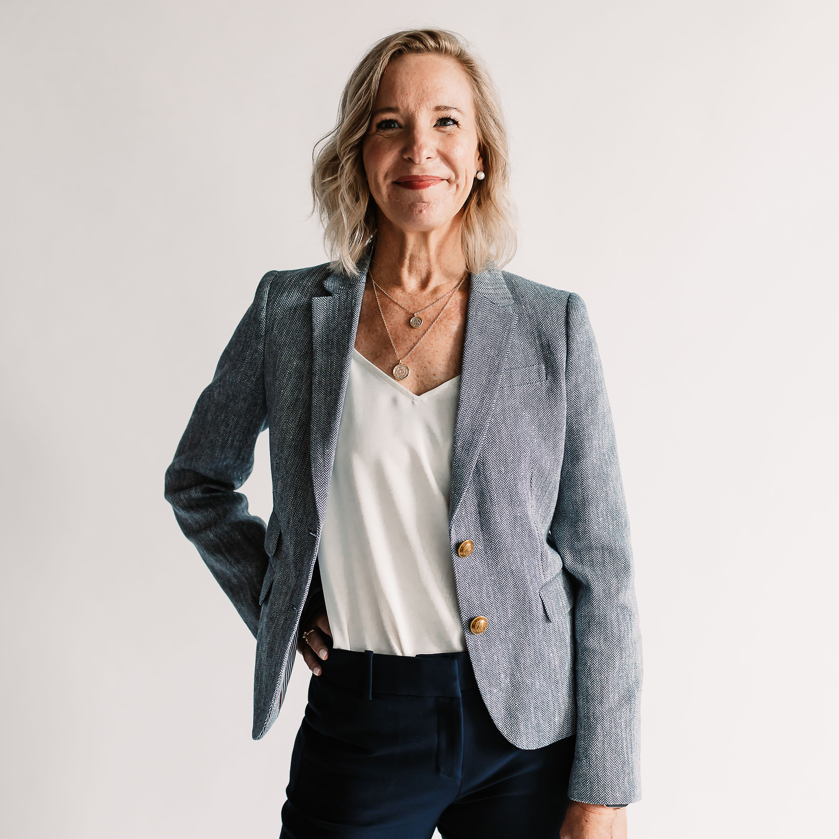 New President of PM, Sarah Miller standing with her hand on her hip