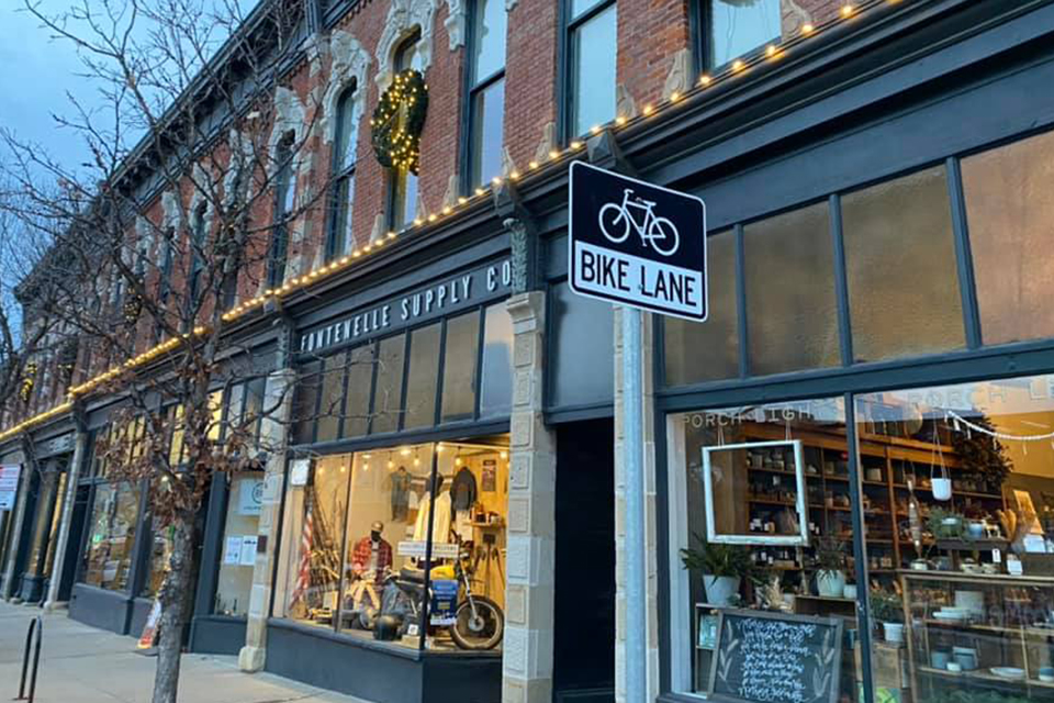 East Village neighborhood shops lit up at dusk. 