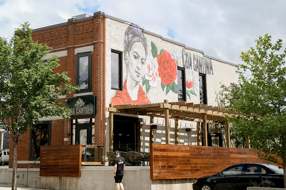 East Village building with white, pink, and green mural on the side.
