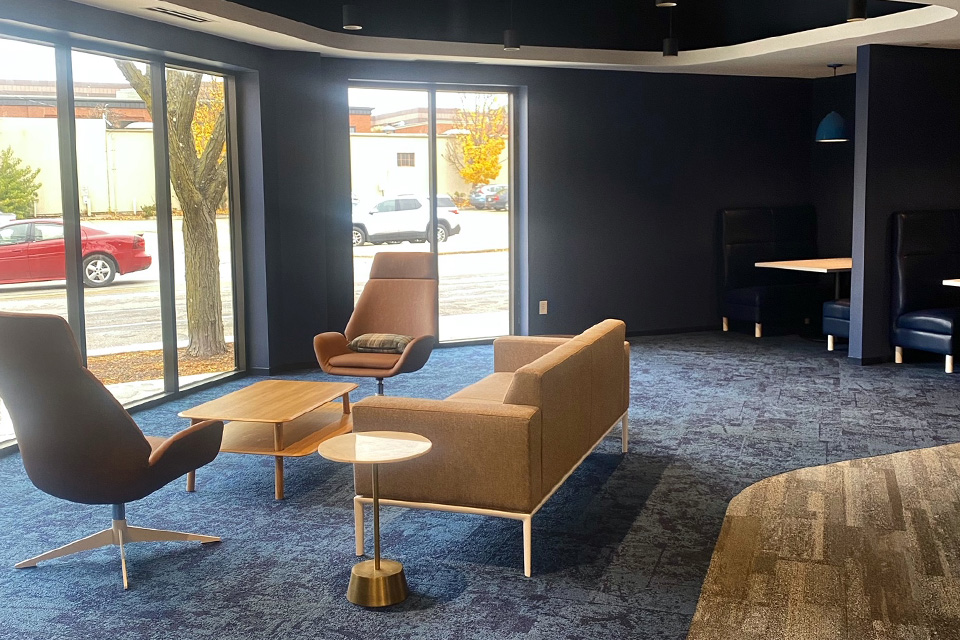 Casual meeting space inside the Anthologic office with a brown leather couch and chairs. 