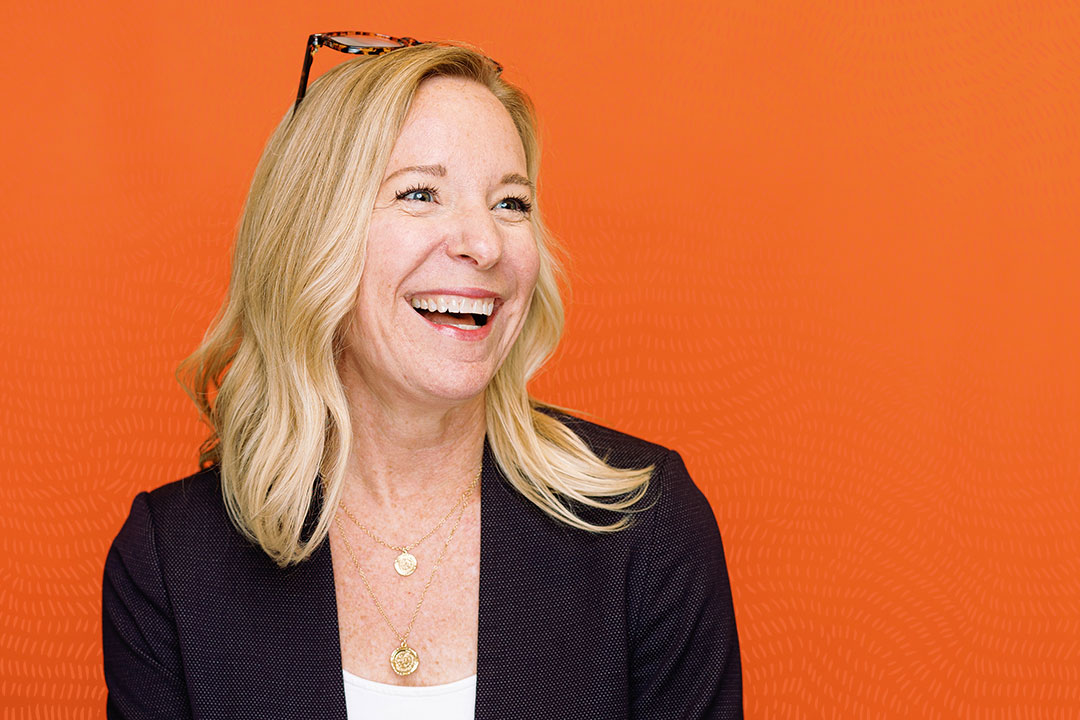 Sarah Miller against orange background with pattern