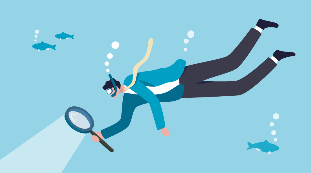 Man snorkeling underwater and looking through magnifying glass.
