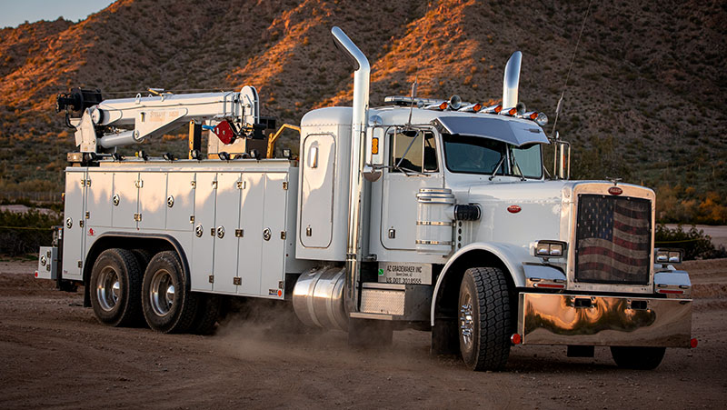 Semi truck cab with Stellar trailer parked at the base of desert mountains - thumbnail.