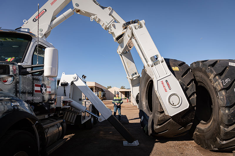 A TM16160 tire manipulator with a 28000 service crane picking up a tire. 