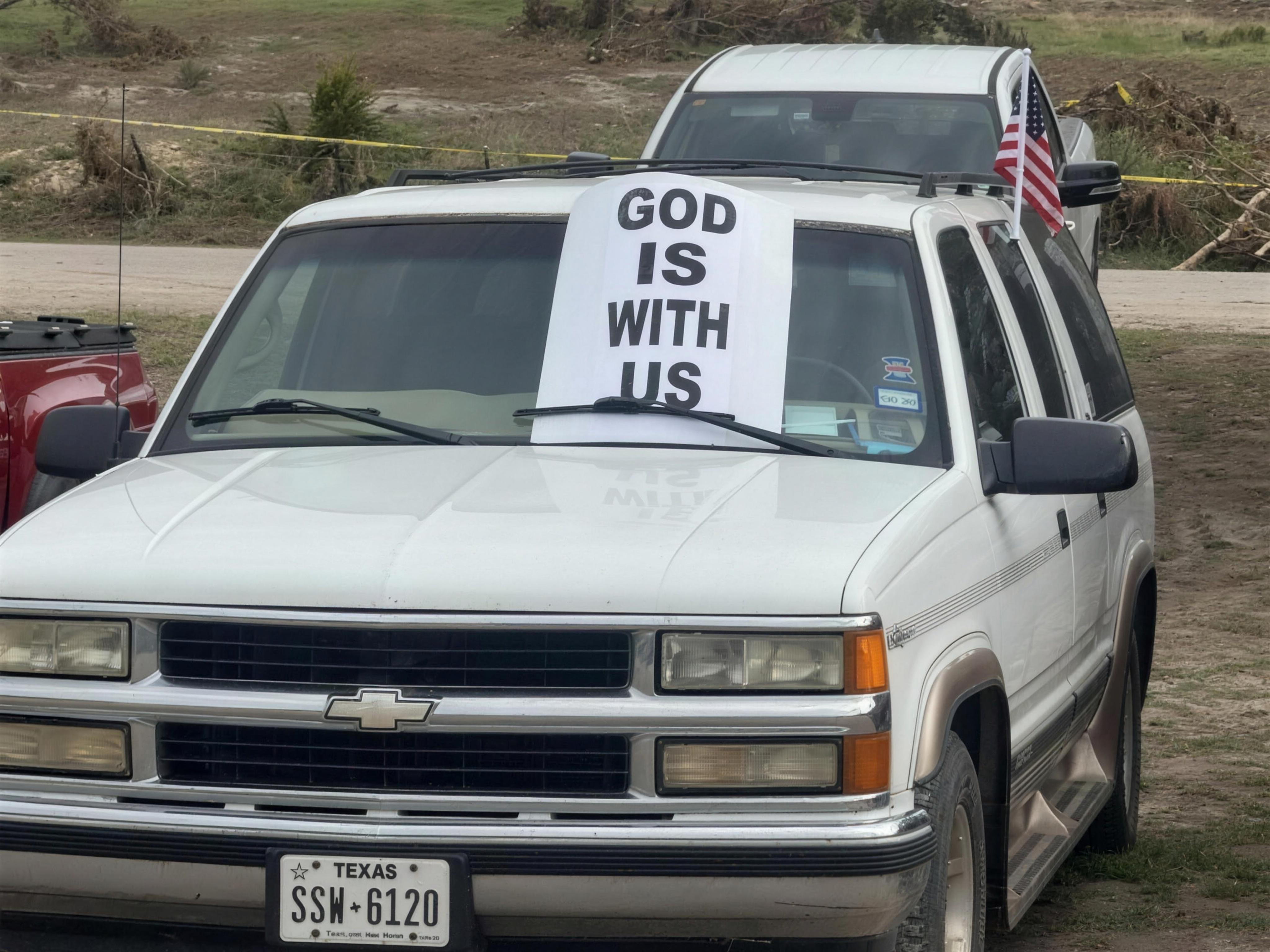 Truck with a GOD IS WITH US window sign at the Texas Hill Country response site