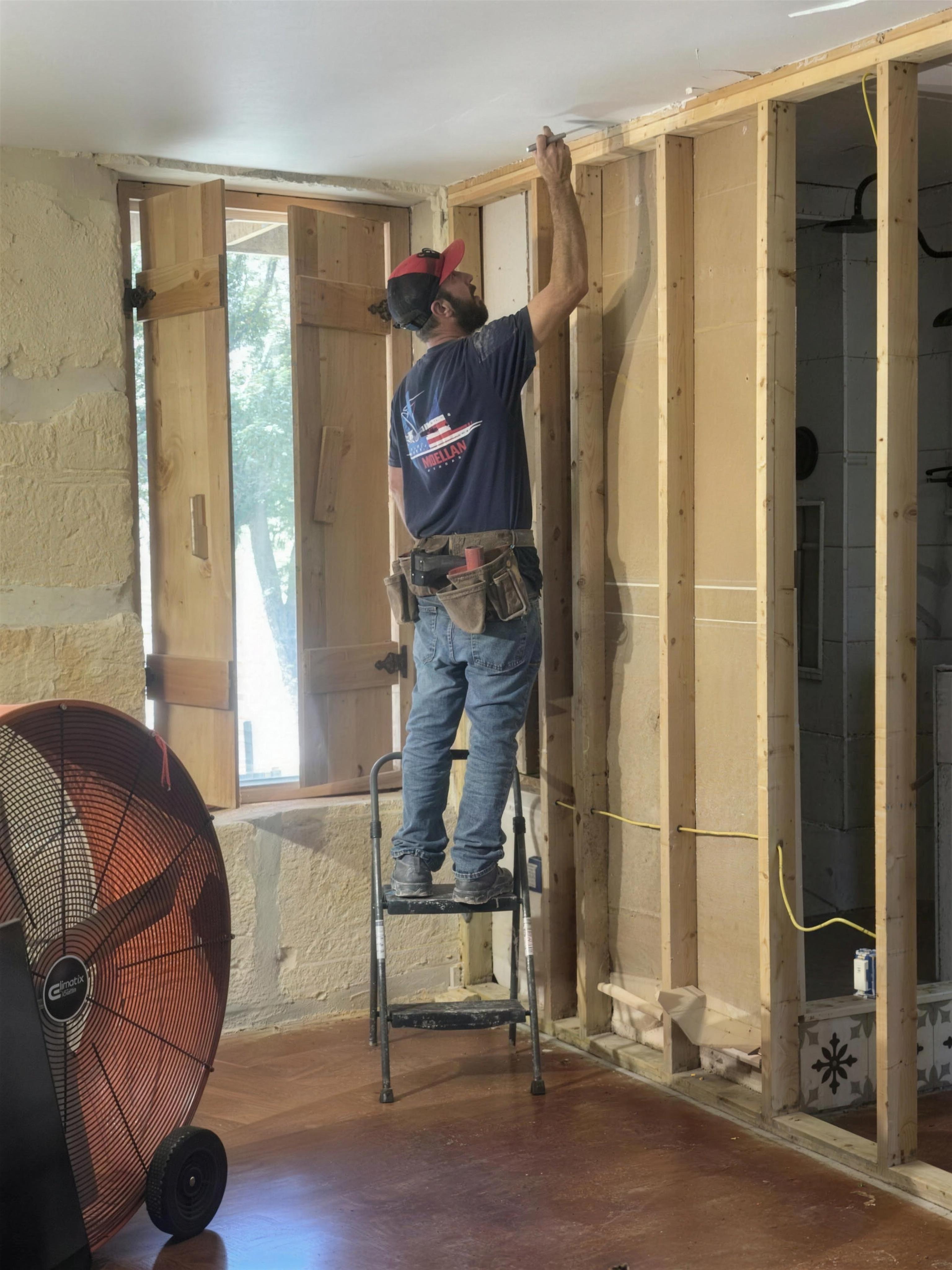 Volunteer on a ladder working on interior framing