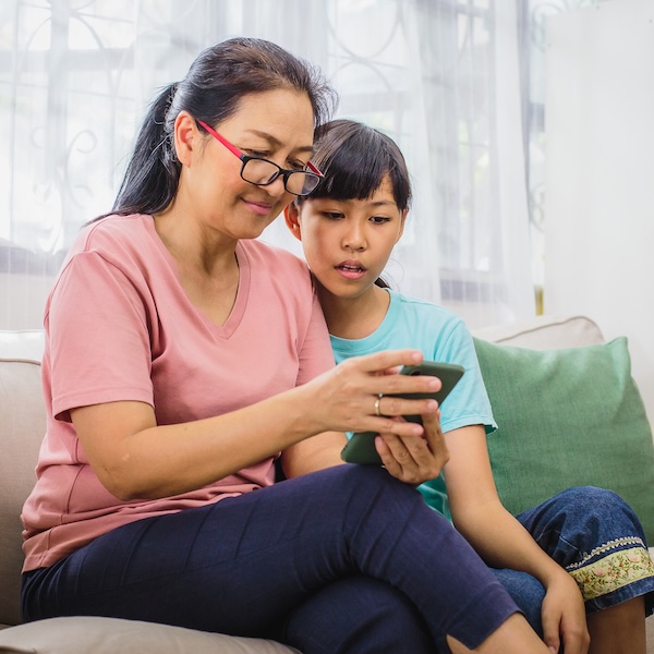 A mother and her child looking at the mother's phone together.