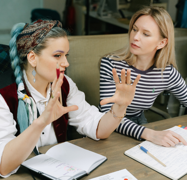Two women in conversation, one using her hands descriptively.