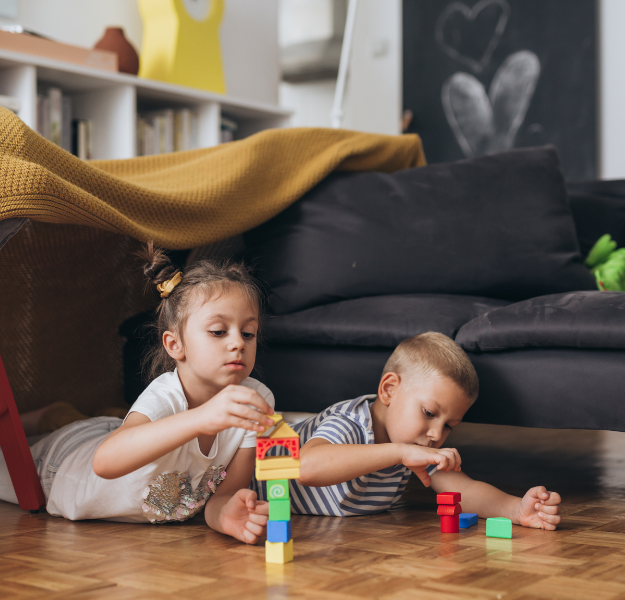 Two kids playing with to blocks.
