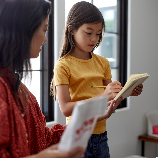 Image of young girl writing on a notepad.