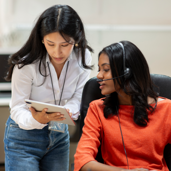 Image of two women looking at a handheld device.