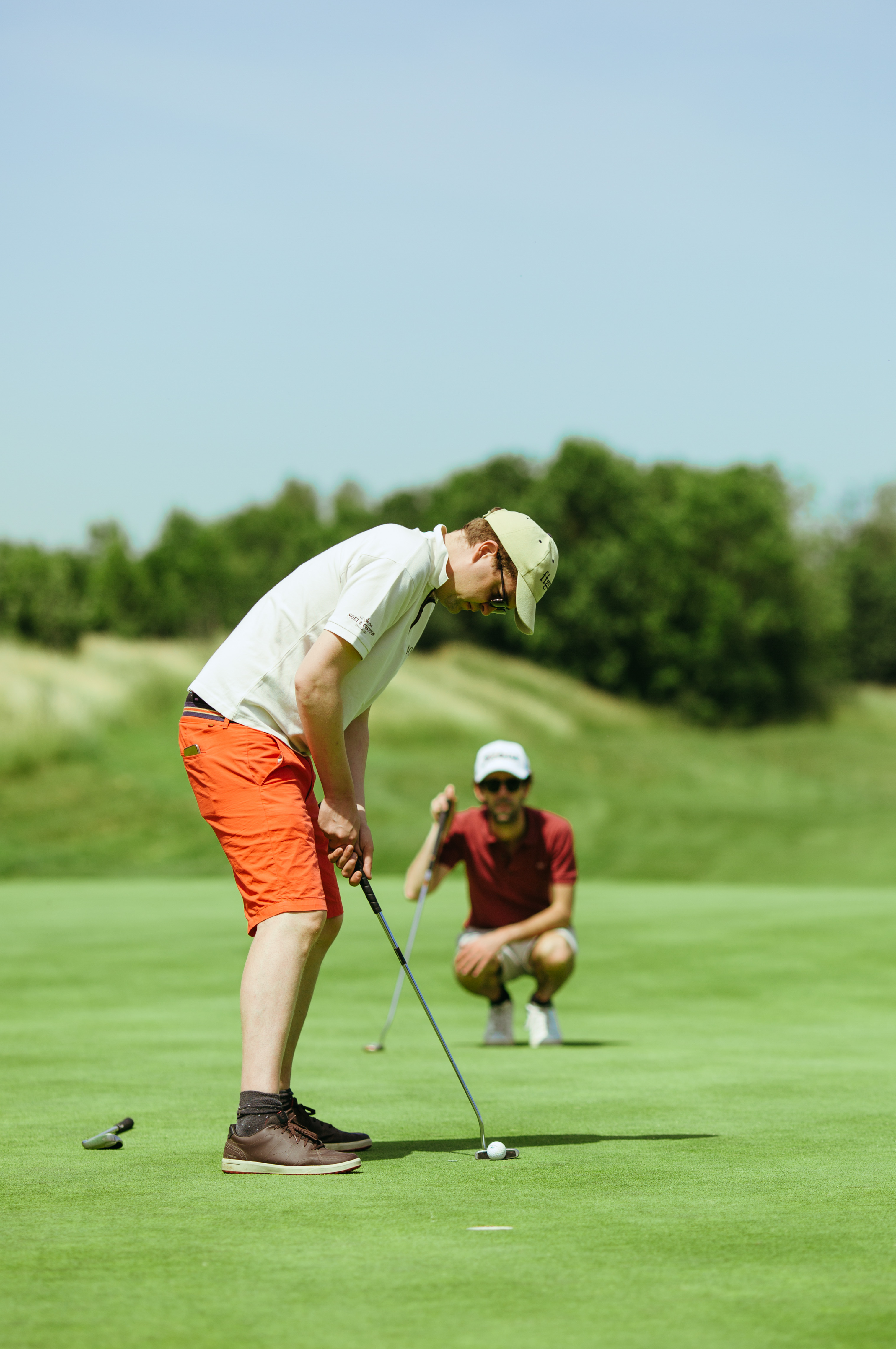 Golfeur à quelques mètres du trou ajustant son tir