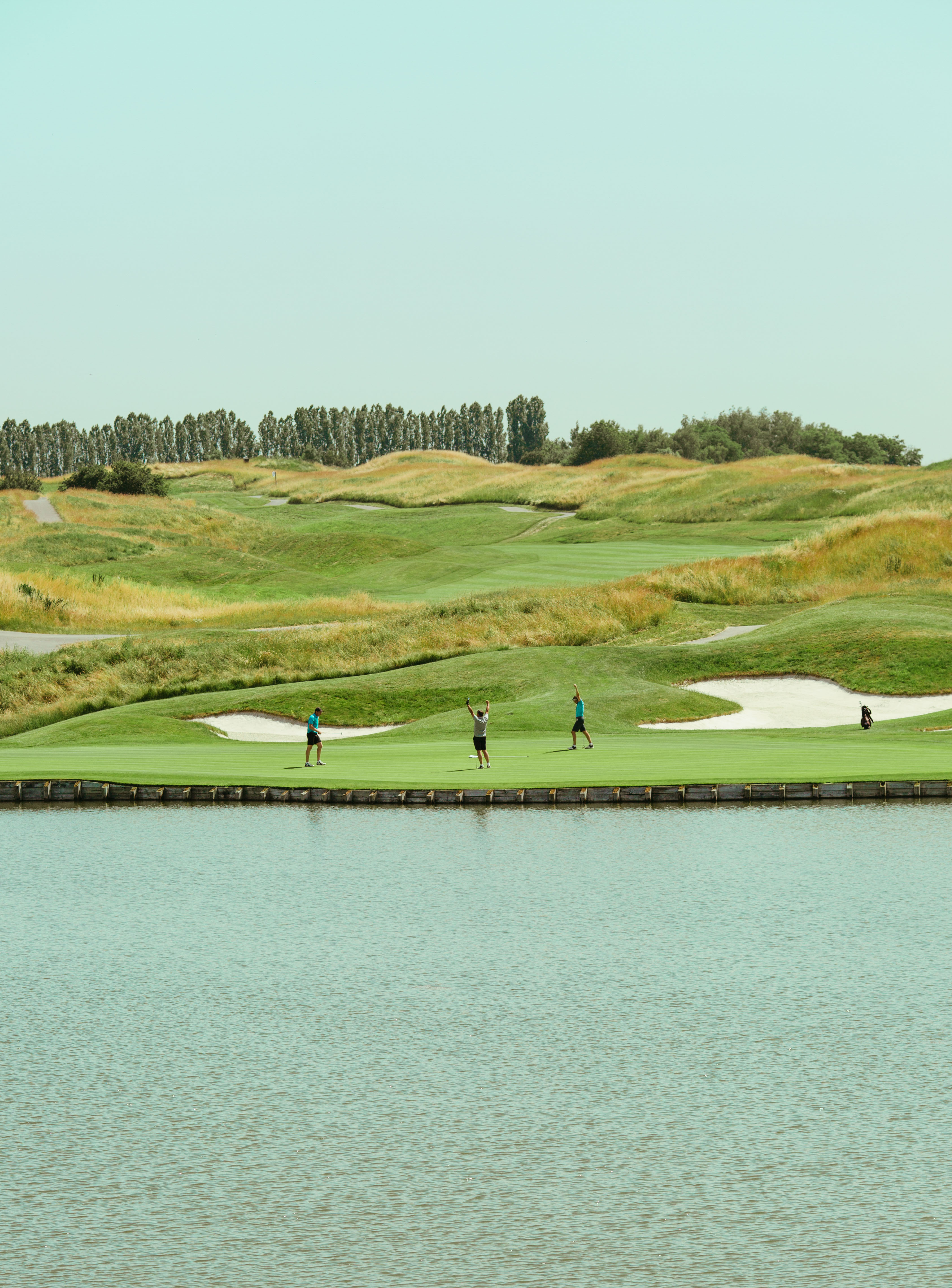 Golfeurs devant un étang ayant réussi un trou